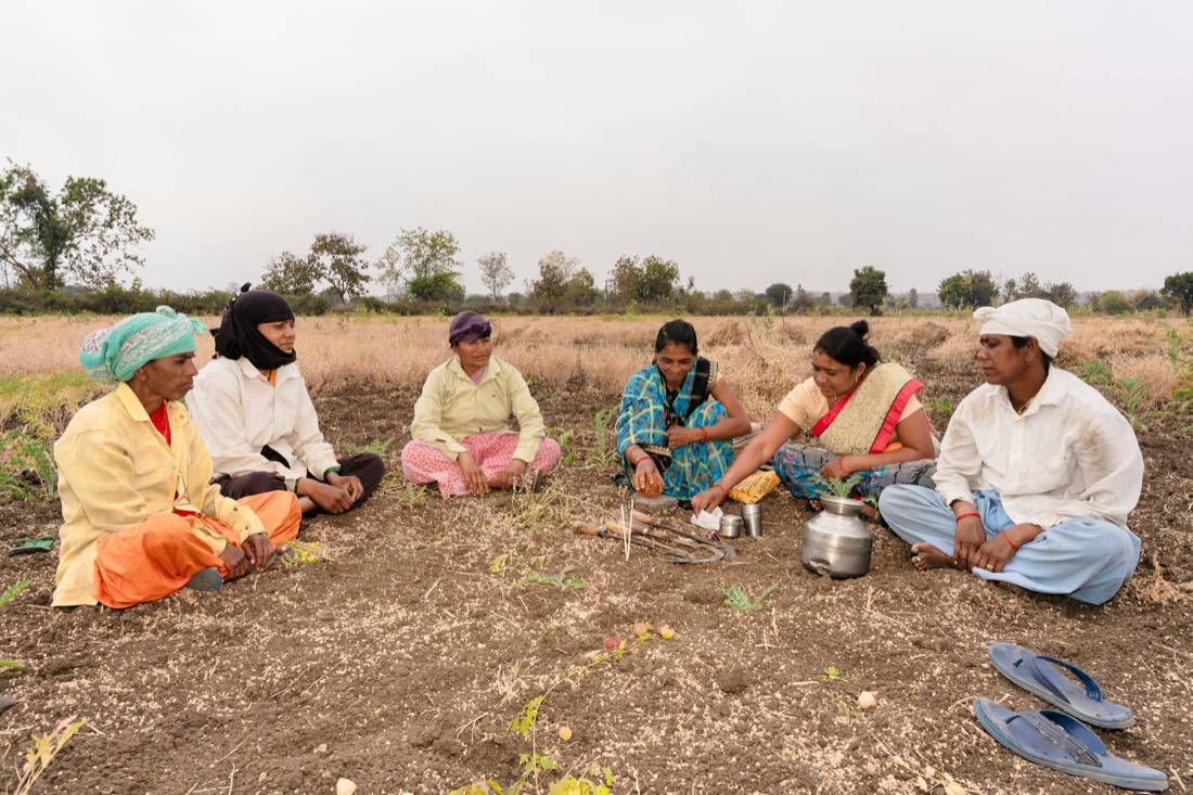 A group of farmers sitting together in a field